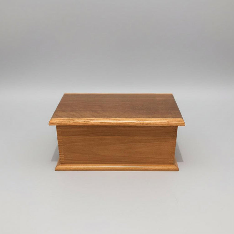 A handcrafted wooden keepsake box made of Spotted Gum timber, with a flat lid and resting on a wooden surface.