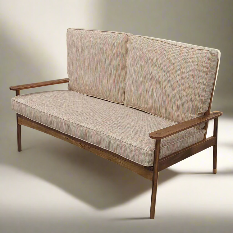 Two-seater sofa with wooden frame and patterned cushions on a neutral background