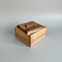 Wooden box with a hinged lid on a wooden surface