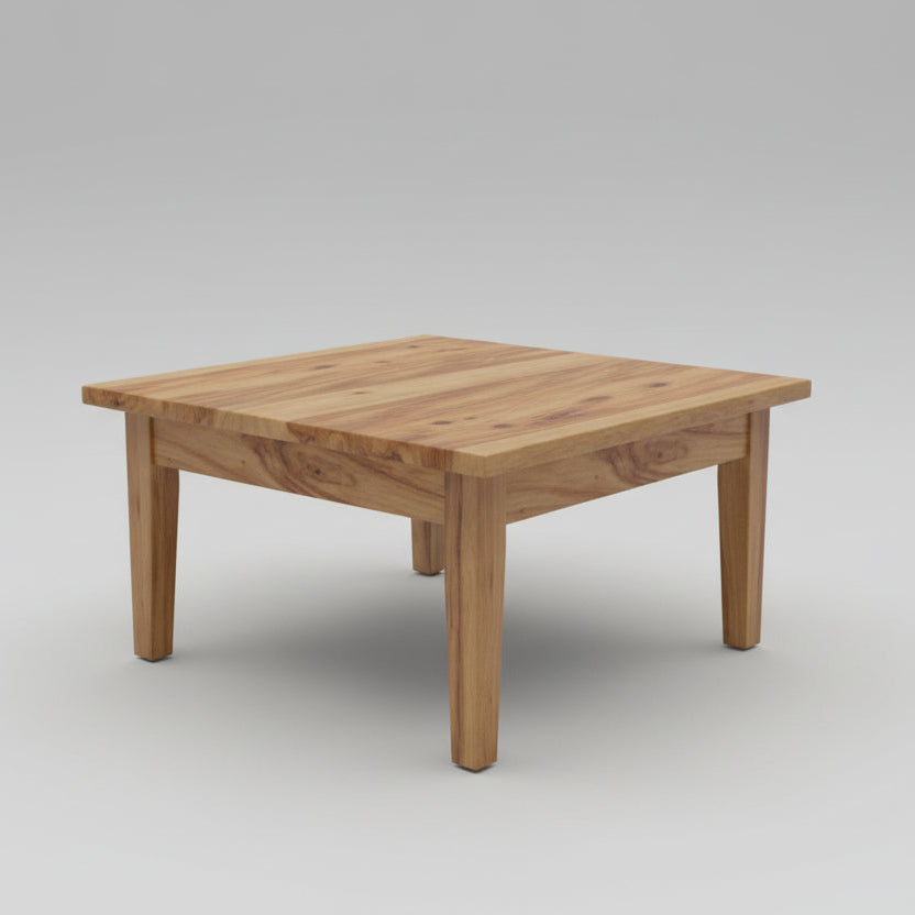 Wooden coffee table in a living room with chairs and a lamp in the background.