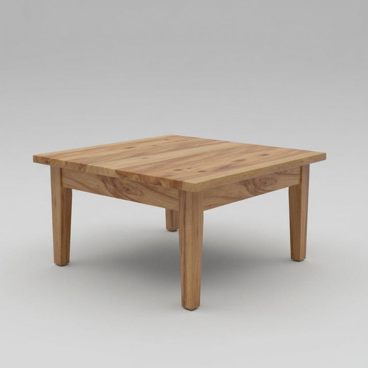 Wooden coffee table in a living room with chairs and a lamp in the background.