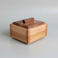 Wooden box with multicolored slats on a wooden surface