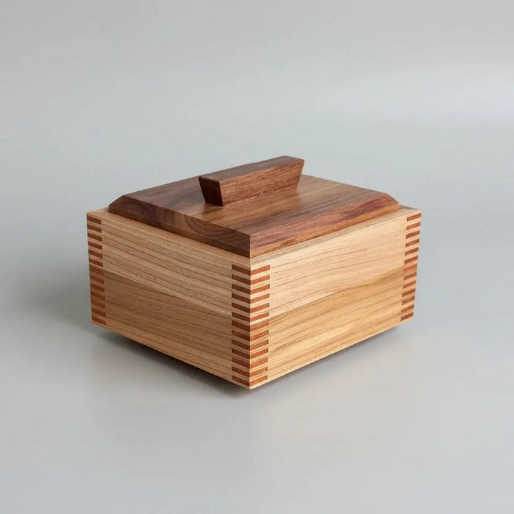 Wooden box with multicolored slats on a wooden surface