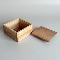 Wooden box with lid on a wooden surface