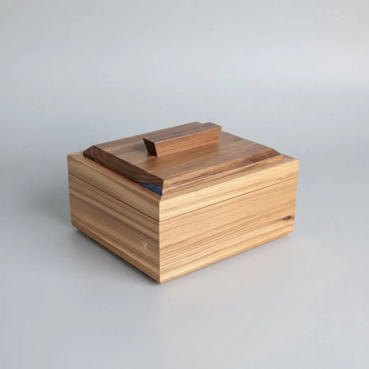Wooden box with a striped pattern on a wooden surface