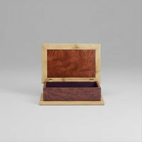 Wooden jewelry box with a mirror on a wooden surface