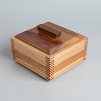 Wooden box with a striped pattern on a wooden surface