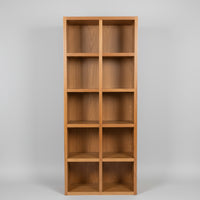 A Spotted Gum Pigeon Hole Unit with multiple shelves, featuring a backing and Spotted Gum beading on the front, placed in a showroom setting with various cushions on top.