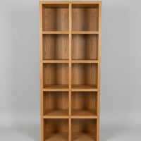A Spotted Gum Pigeon Hole Unit with multiple shelves, featuring a backing and Spotted Gum beading on the front, placed in a showroom setting with various cushions on top.